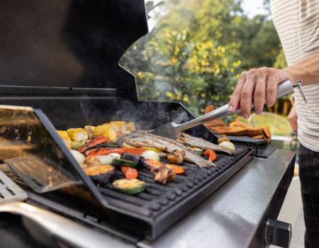 man grilling veggies and fish