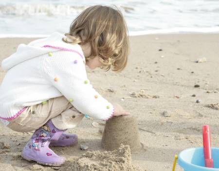 kid making sand castles on the beach