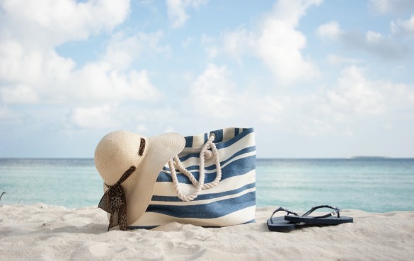 beach bag, flip flops, and hat on the beach | better beach rentals