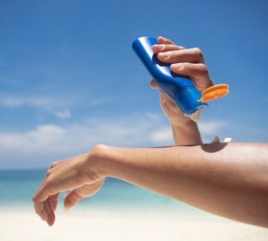 person applying sunscreen on the beach | better beach rentals