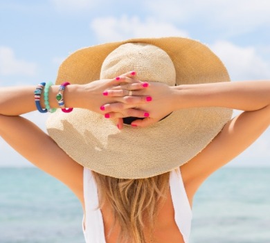 woman wearing hat on the beach | better beach rentals