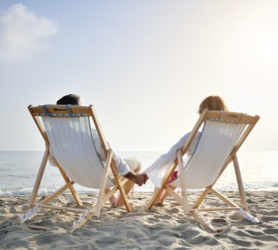 couple sitting in beach chairs on the beach | Better Beach Rentals